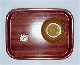 Small wooden tray with coffee and a petit four from above