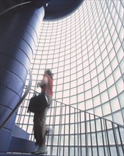 Woman going up the stairs of a staircase with glass blocks