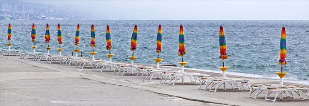 Umbrellas and deckchairs during the preseason on the beach of Opatija on the Mediterranean Sea in Kvarner Bay