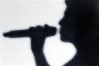 Shadow of a singer with microphone
