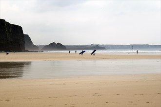 Surfers on the beach at low tide