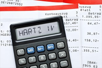 Calculator with the term "Hartz IV" in the display and bank statements