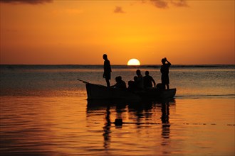Fishermen on a boat at sunset