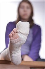 Young woman with a bandaged toe