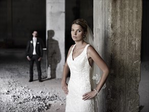 Bridal couple standing in an old industrial hall