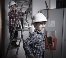 Two boys wearing helmets playing construction workers