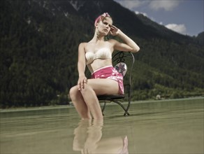 Woman sitting on a chair in the water
