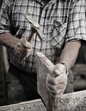 Stonemason working on a stone slab with a hammer