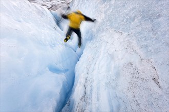 Mountaineer jumping into a small crevasse on Matanuska Glacier