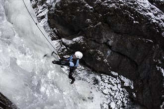 Ice climber climbing a frozen waterfall