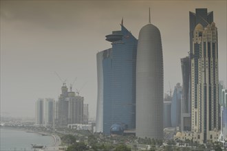 Smog over Corniche waterfront promenade with the skyline of Doha with Al Bidda Tower
