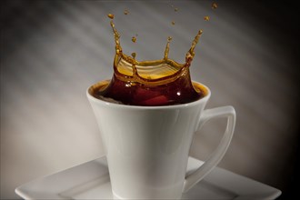 Sugar cube falling into a cup of coffee