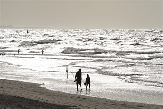 Man and child walking on the beach