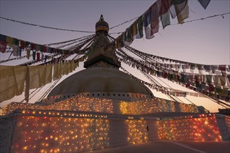 Boudhanath Stupa decorated with prayer flags and lights for the full moon festival
