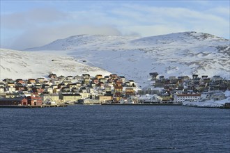 Buildings at the harbour in front of the mountains of the island