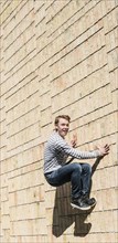 Young man doing parkour jump on brick wall
