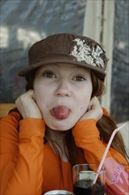 Naughty girl with cap sticking out her tongue