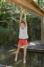 Girl swinging above water
