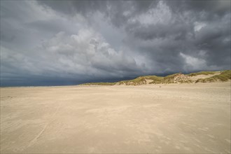 Dramatic storm clouds over beach and dunes