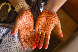 Henna-painting on hands at a wedding ceremony
