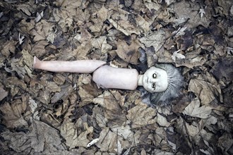 Broken doll lying in the front garden of an abandoned kindergarten