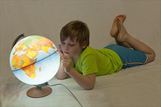 Boy looking at an illuminated globe
