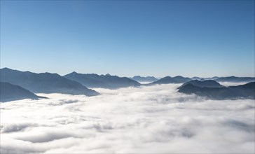 View of mountain peaks with fog over the valley
