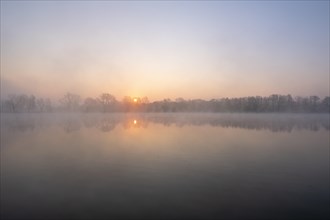 Sunrise in the fog at a pond