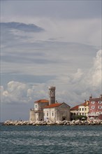 View of the town of Piran with lighthouse and the Church of Our Lady of Health