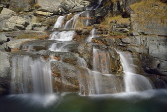 Mountain river falls in several cascades into the river Grand Eyvia
