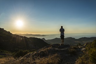 Young man photographing the sunset