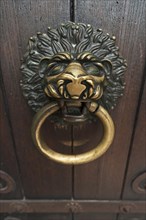 Lion head as a door knocker on the Romanesque entrance portal of the Scots monastery of St. Jacob
