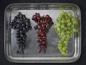 Three varieties of grapes on a silver platter