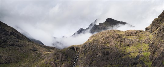 Allt a' Chaoich waterfall with peaks of Sgurr Dubh Beag and Sgurr Dubh Morr of Cuillin Hills behind