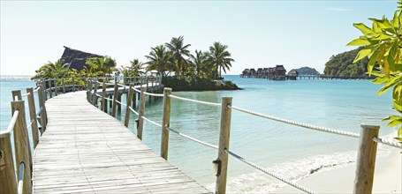 Wooden walkway to overwater bungalows in the sea
