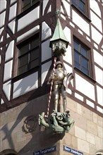 Figure of a knight on the facade of a half-timbered house