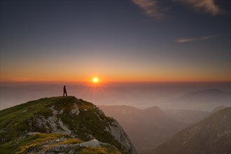 Sunset with hiker on a summit of the Allgau Alps