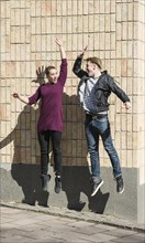Young man and woman jumping and doing a high five greeting