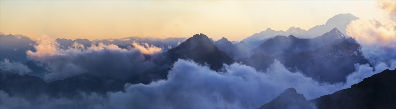 Panorama of the Alps at sunset in the fog