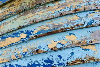 Blue and light blue peeling paint on an old fishing boat