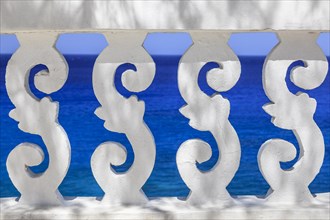White ornate railing with views of the sea