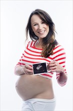 Pregnant woman holding an ultrasound image