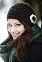 Smiling young woman wearing hat and scarf in winter