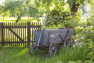 Old wagon in front of a garden gate