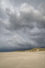Dramatic storm clouds over beach and dunes