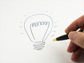 Hand drawing a light bulb