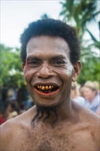 Man with red teeth from eating beetle nut and unusal beard