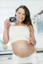 Pregnant woman holding an ultrasound image