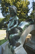 Child's sculpture with musical instrument and fish fin on Minnesangerbrunnen fountain