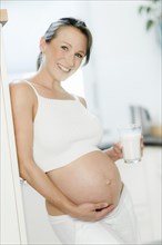 Pregnant woman holding a glass of milk